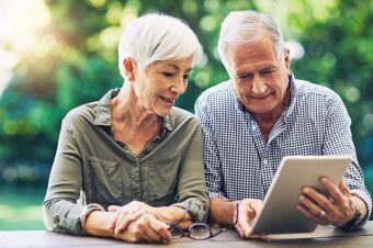 Ein Ehepaar schaut in ein Tablet