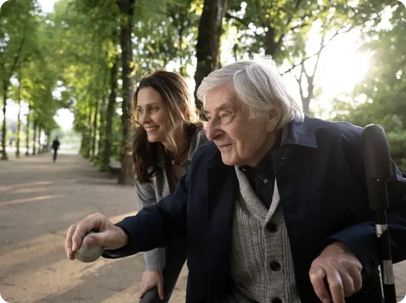 Eine ältere Dame (rechts) und ihre Betreuuerin im Park