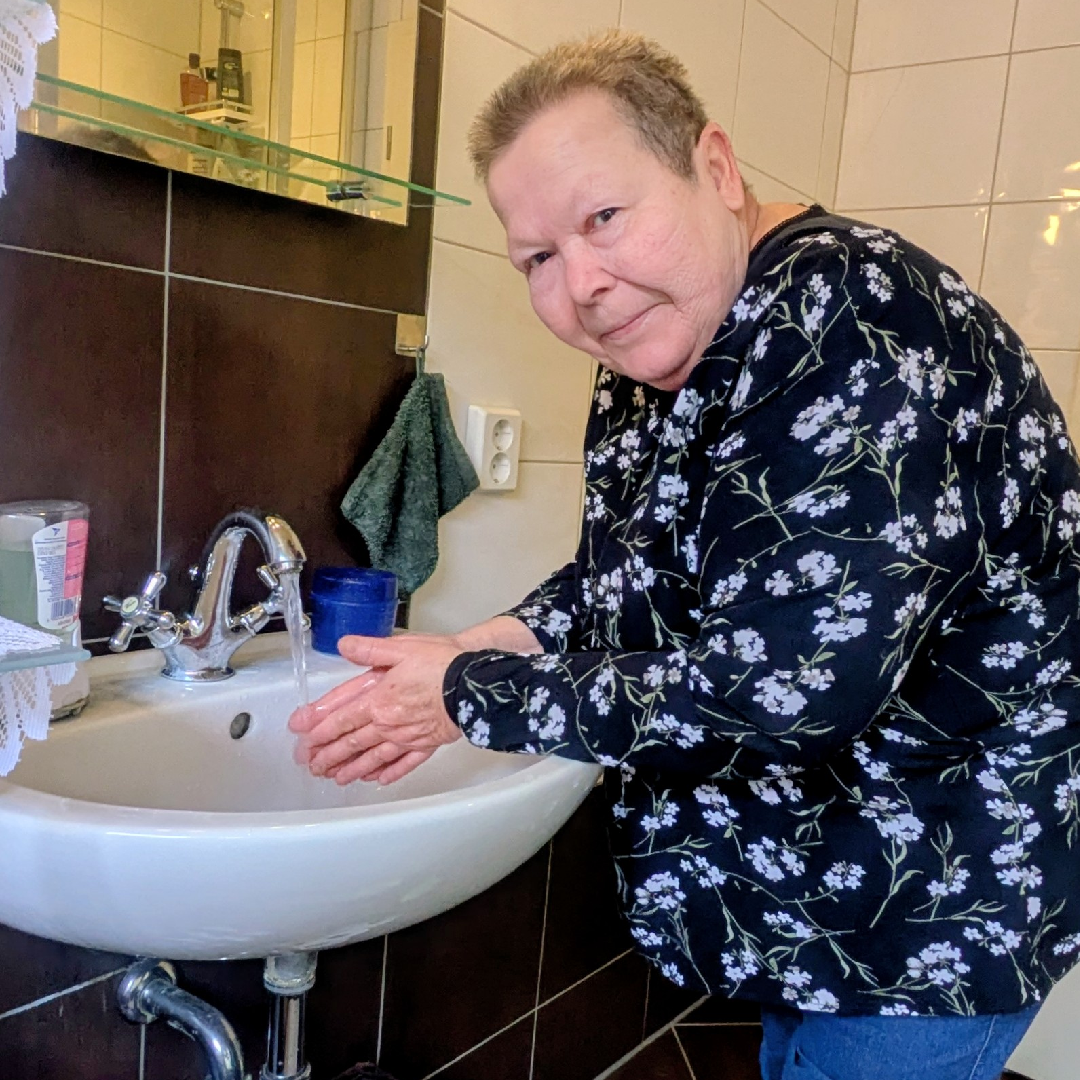 Frau Knebel am alten Waschbecken vor dem Badumbau